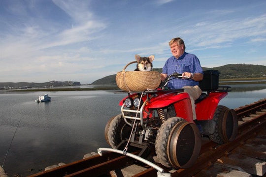 William Smith brings Morgan the Corgi from Featherbed Nature Reserve to Knysna via the railway bridge on the Knysna Lagoon using his specially adapted quad bike. This photo was taken sometime after the 2006 closure of the railway line.